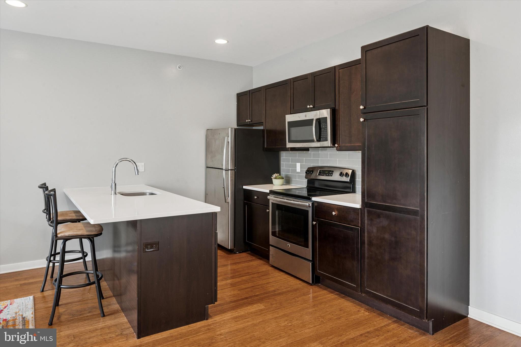 1608 Ridge Avenue, Unit 403 Philadelphia, PA 19130 - Photo 9 of 18 a kitchen with stainless steel appliances a refrigerator and a stove top oven