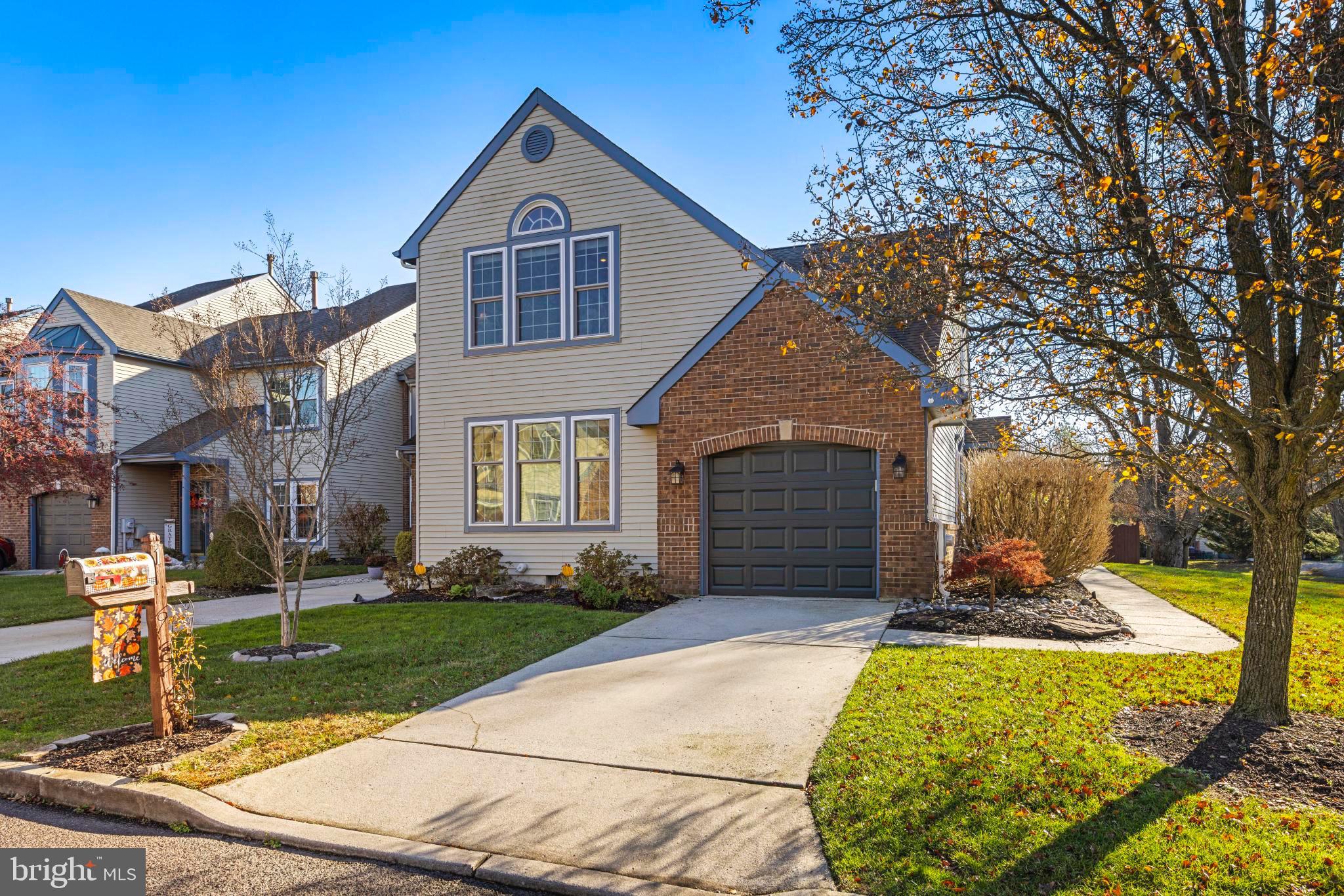 a front view of a house with a yard outdoor seating and covered with trees