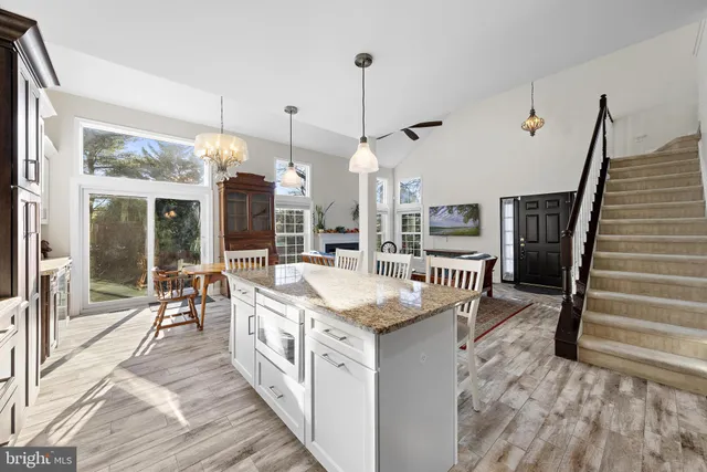 a kitchen that has a stove a sink a microwave a dining table and chairs