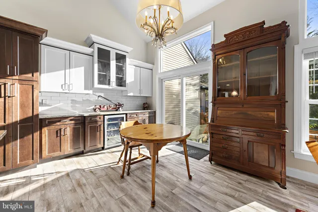 a kitchen with stainless steel appliances kitchen island granite countertop a table chairs and a wooden floor