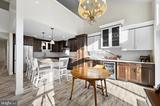 a kitchen with stainless steel appliances granite countertop a table chairs stove and cabinets