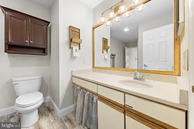 a bathroom with a granite countertop toilet sink and mirror