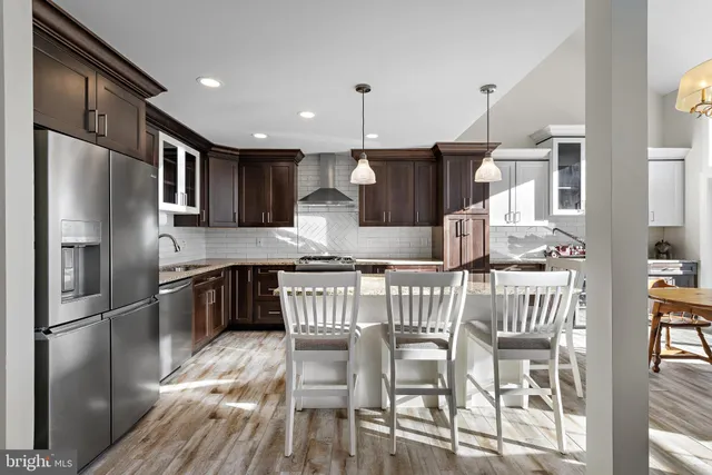 a kitchen with stainless steel appliances granite countertop a sink a stove and a refrigerator