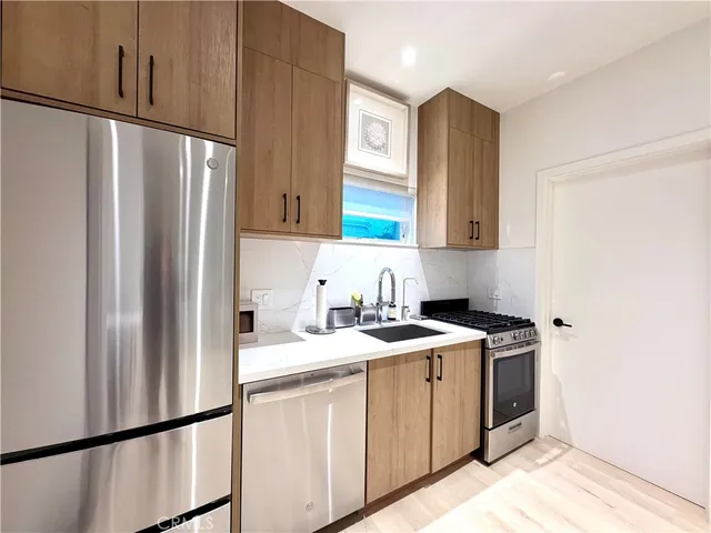 a kitchen with stainless steel appliances granite countertop a refrigerator and a sink