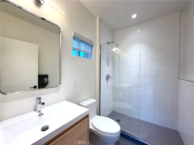 a bathroom with a sink mirror toilet and shower