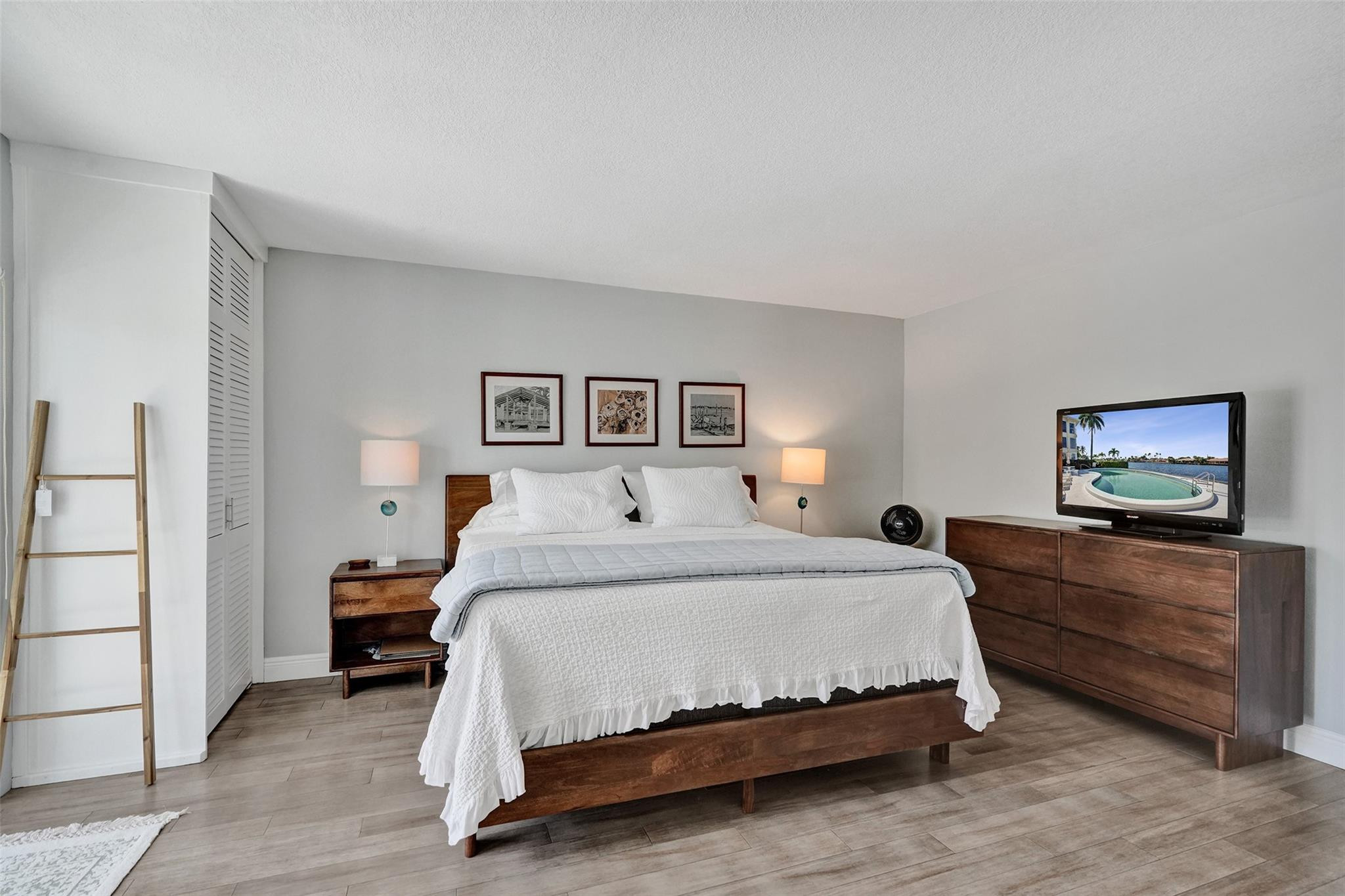 801 North Riverside Drive, Unit 4B Pompano Beach, FL 33062 - Photo 17 of 43 a spacious bedroom with a bed and a painting on the wall