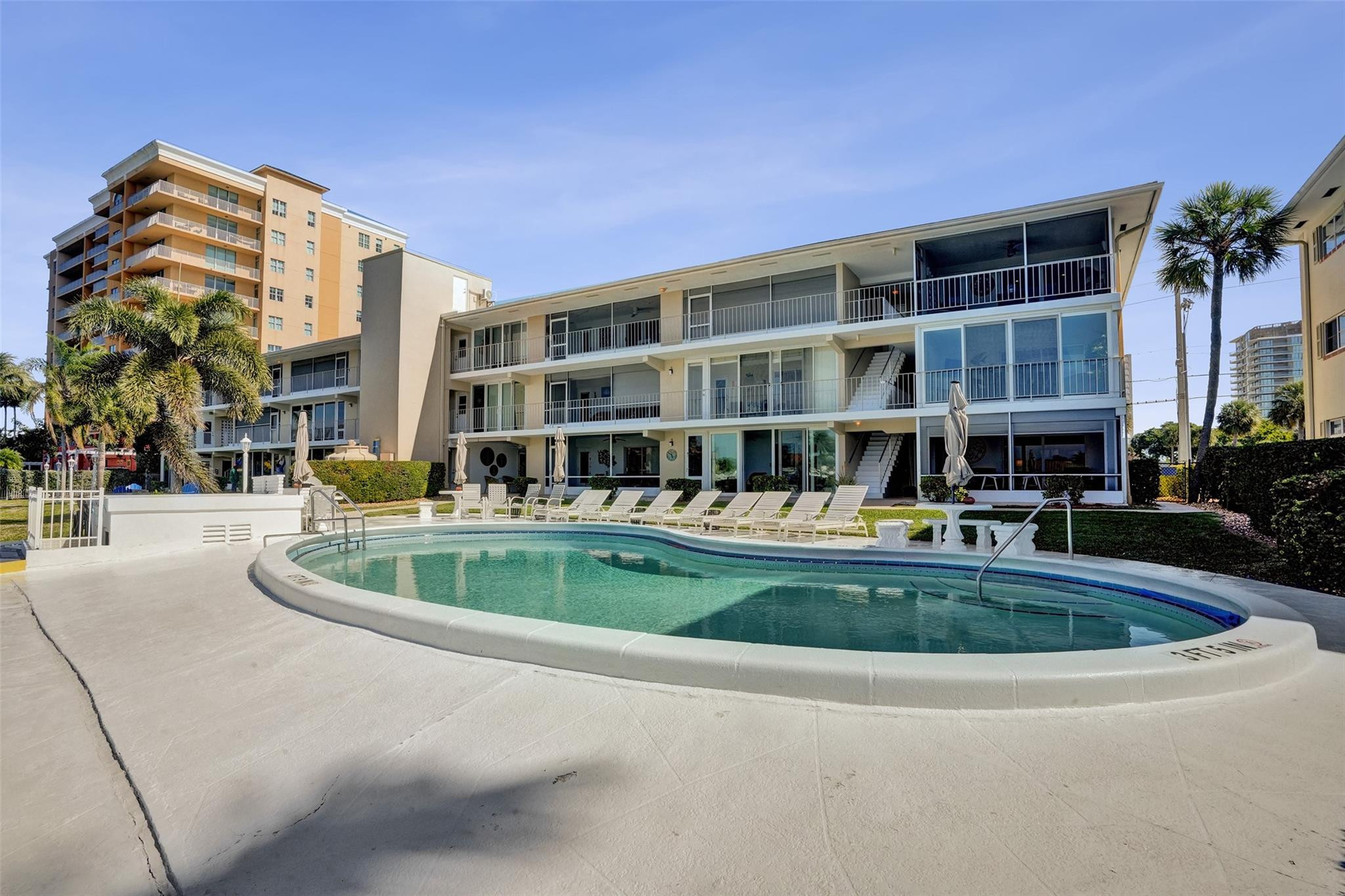 801 North Riverside Drive, Unit 4B Pompano Beach, FL 33062 - Photo 25 of 43 a front view of buildings with yard and outdoor seating