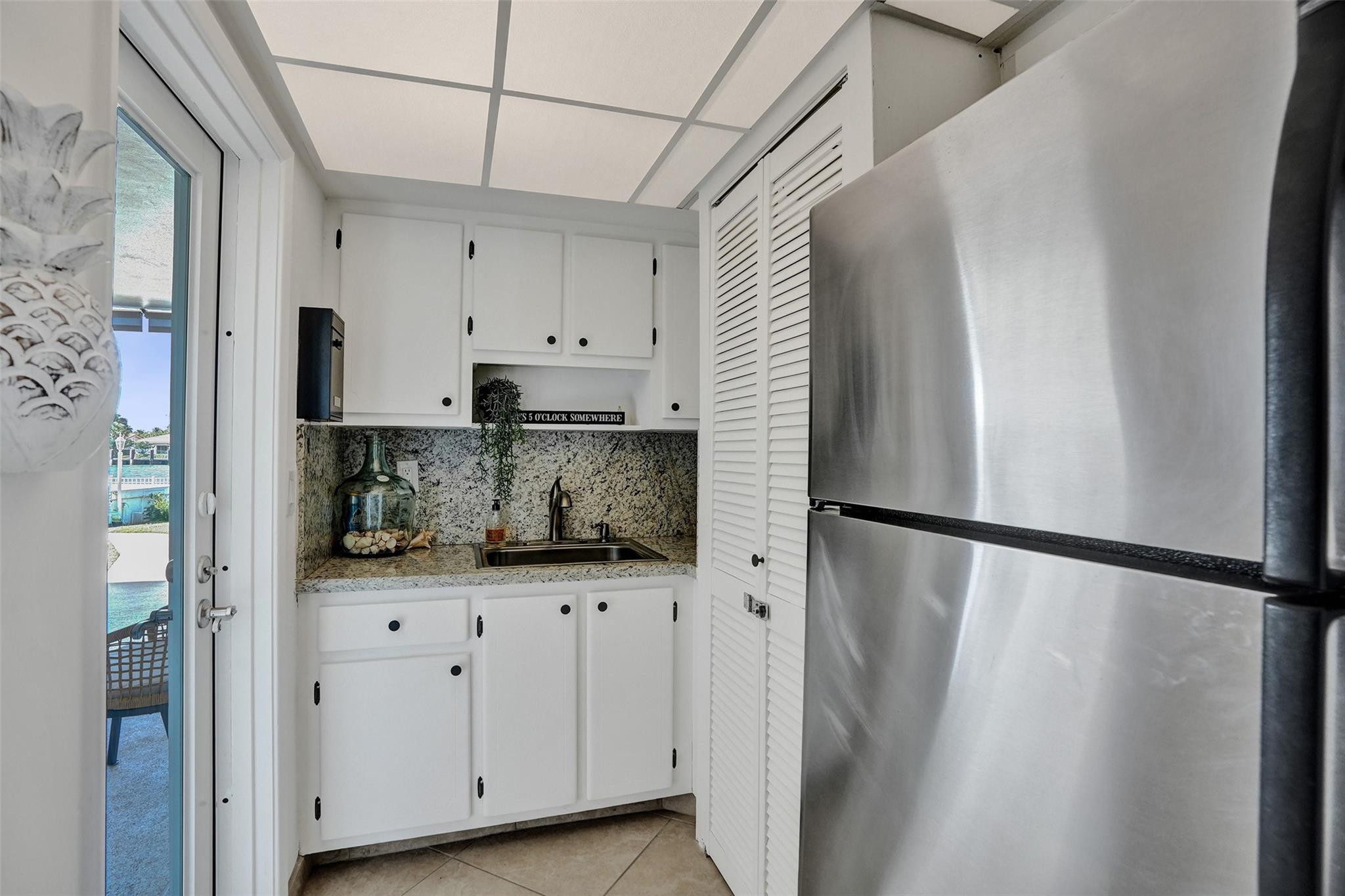 801 North Riverside Drive, Unit 4B Pompano Beach, FL 33062 - Photo 33 of 43 a kitchen with white cabinets and white appliances