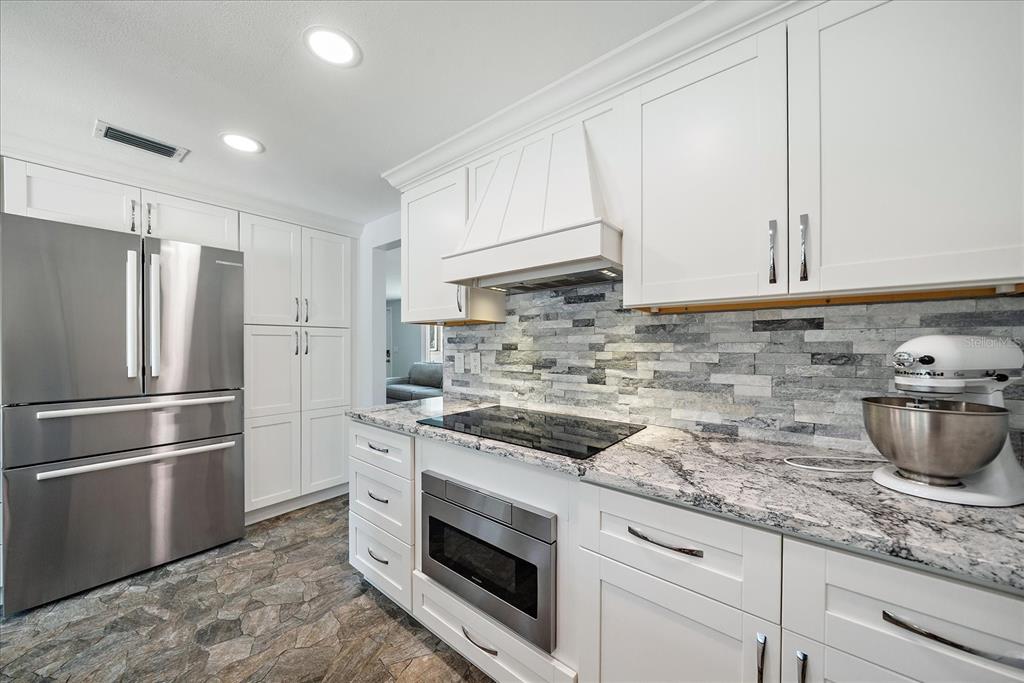 2431 Bispham Road Sarasota, FL 34231 - Photo 11 of 25 a kitchen with granite countertop a sink stove and refrigerator
