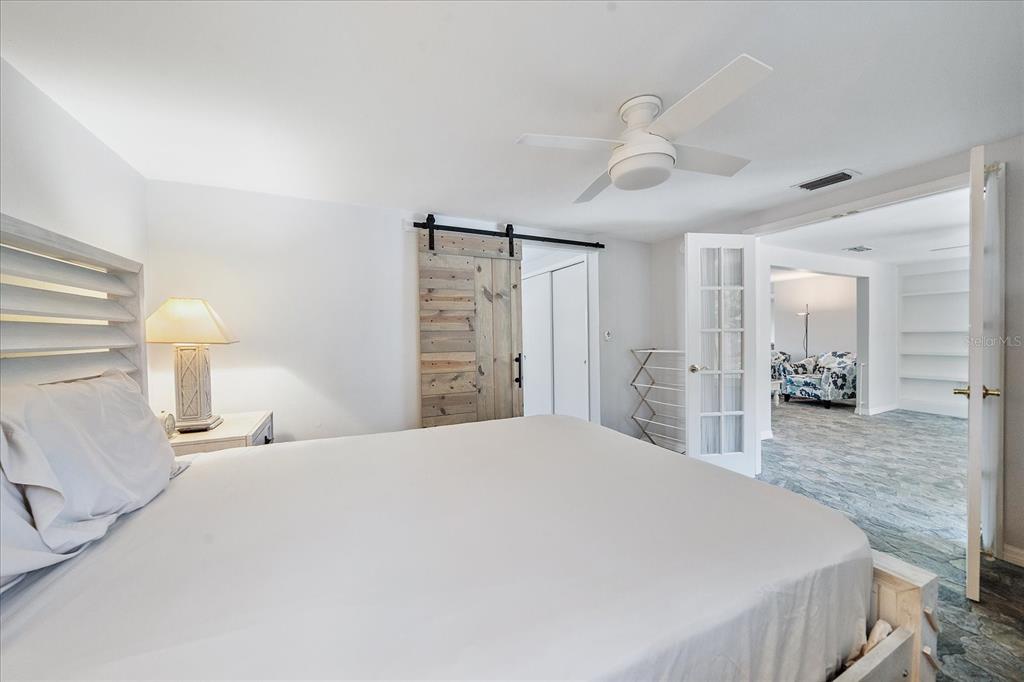 2431 Bispham Road Sarasota, FL 34231 - Photo 16 of 25 a spacious bedroom with a bed and a lamp