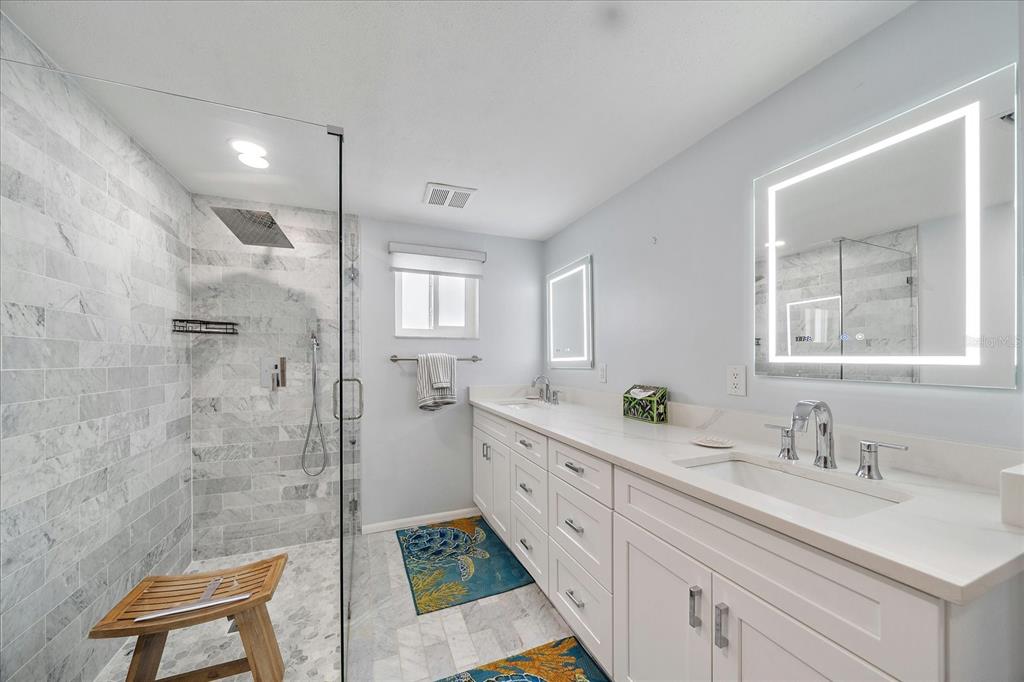 2431 Bispham Road Sarasota, FL 34231 - Photo 17 of 25 a spacious bathroom with double vanity sink a mirror and a shower
