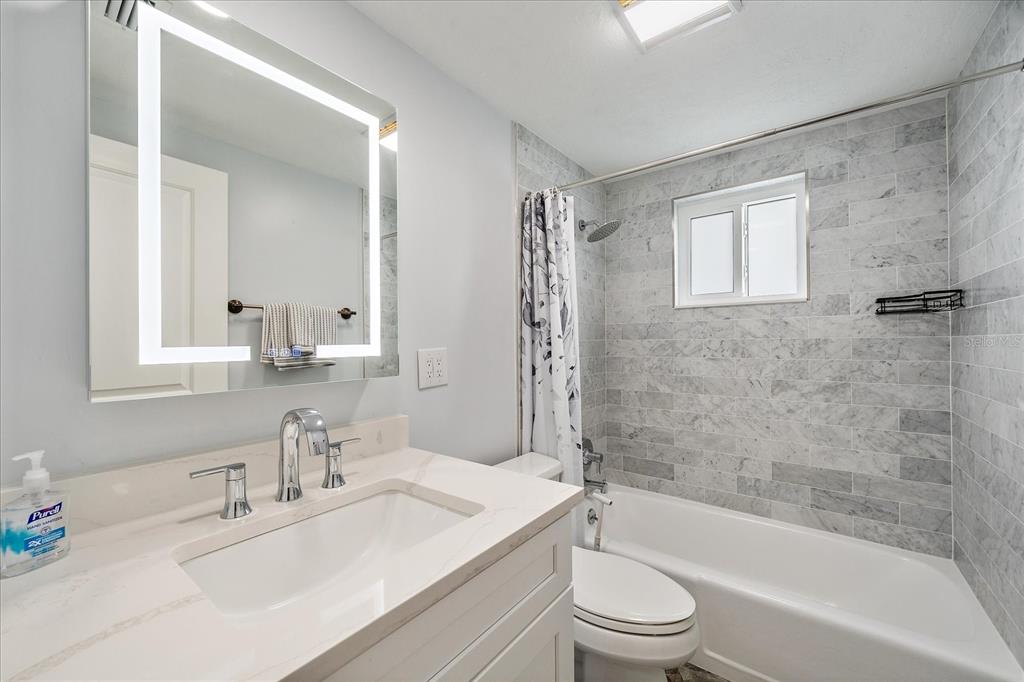2431 Bispham Road Sarasota, FL 34231 - Photo 20 of 25 a bathroom with a bathtub shower sink vanity mirror and toilet