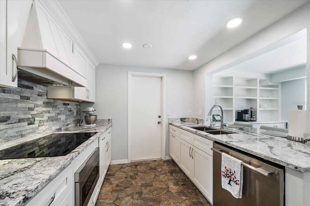 2431 Bispham Road Sarasota, FL 34231 - Photo 9 of 25 a kitchen with stainless steel appliances granite countertop a sink stove and cabinets