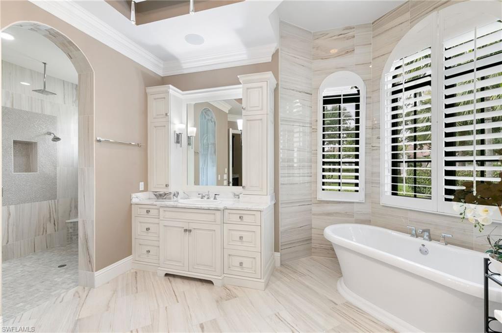 5903 Burnham Road Naples, FL 34119 - Photo 13 of 38 a bathroom with a granite countertop double vanity sink a mirror and a bathtub