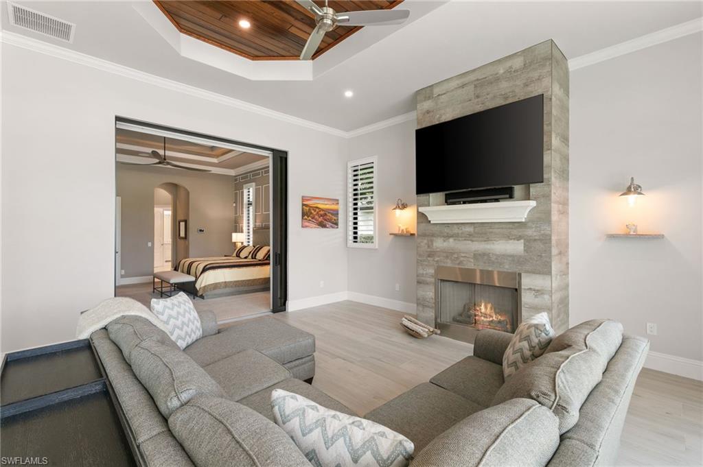 5903 Burnham Road Naples, FL 34119 - Photo 15 of 38 a living room with furniture a flat screen tv and a fireplace