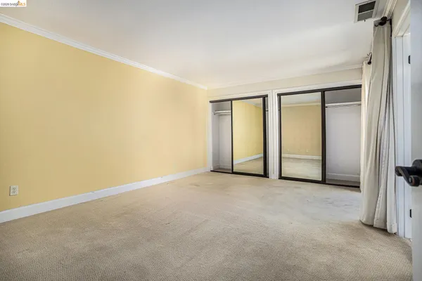 an empty room with windows and closet