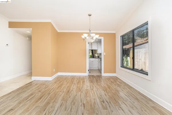 a view of an empty room with glass door and wooden floor