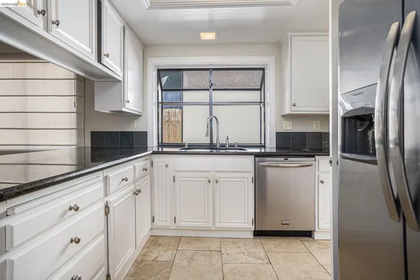 a kitchen with white cabinets and white appliances