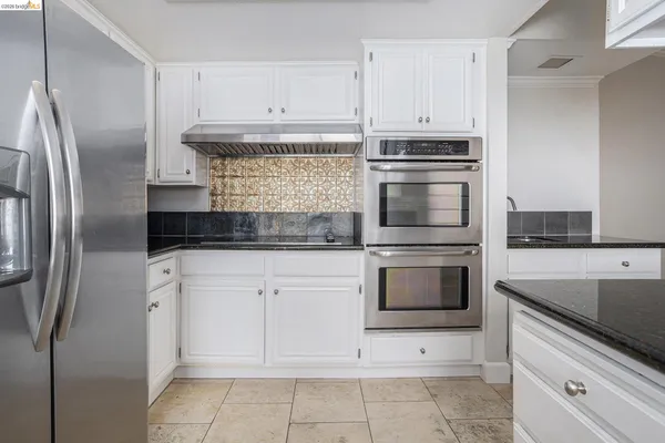 a kitchen with cabinets stainless steel appliances and a counter space
