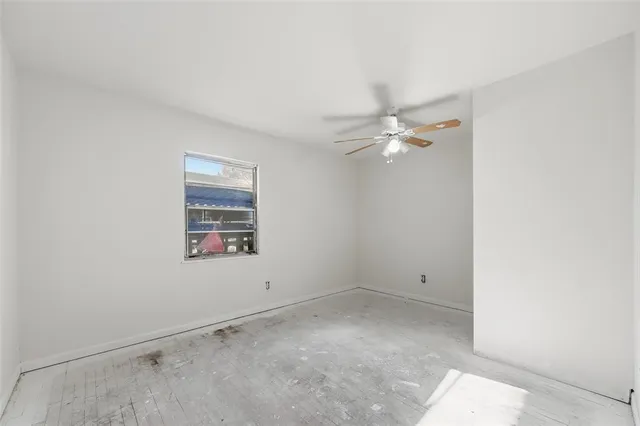 a view of a room with a ceiling fan and a window
