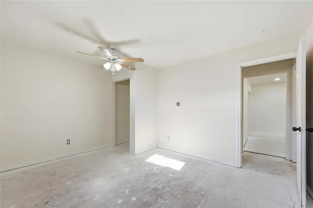 an empty room with a ceiling fan and a window