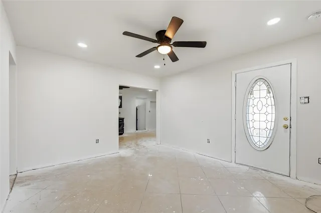 an empty room with fan and windows