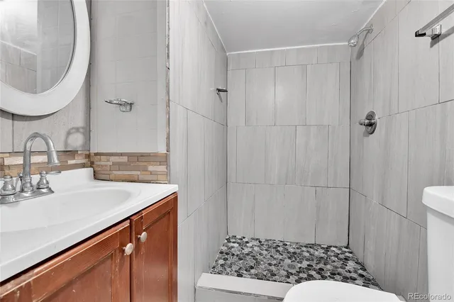 a bathroom with a sink a toilet and shower