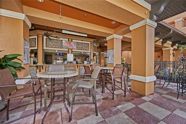 a view of a patio with table and chairs potted plants and floor to ceiling window