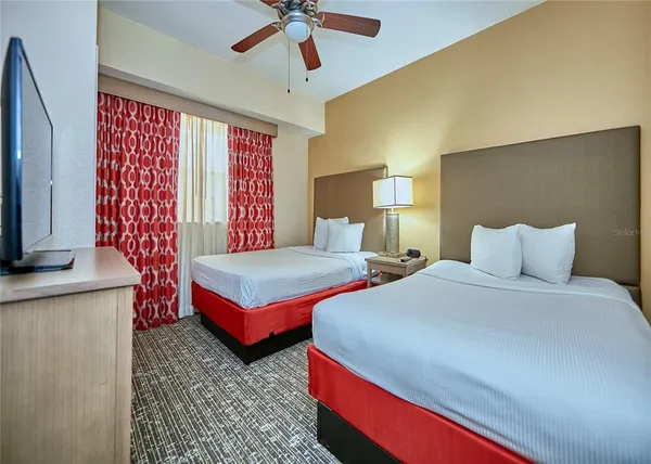 a bedroom with two beds and a chandelier