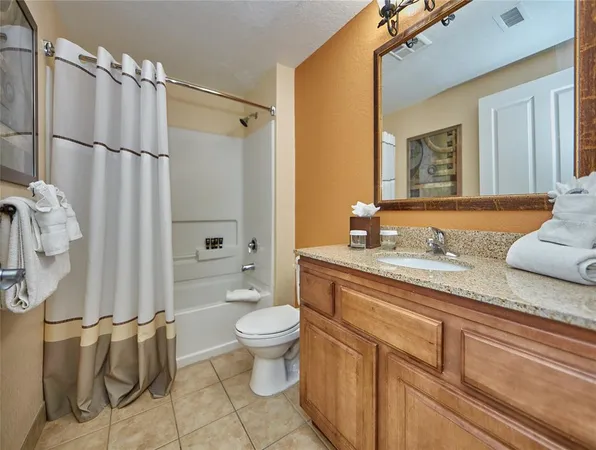 a spacious bathroom with a granite countertop sink toilet mirror and shower