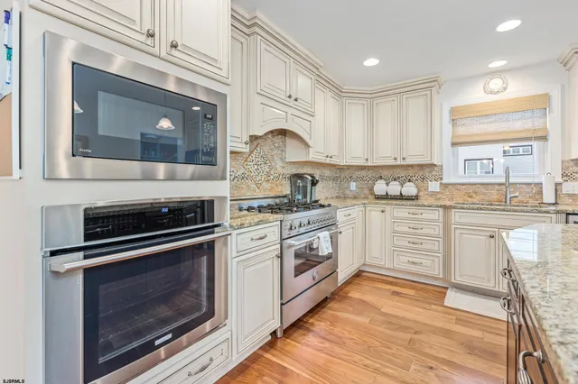 a kitchen with granite countertop a stove top oven microwave and cabinets