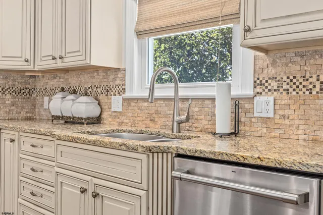 a kitchen with granite countertop a sink and a window