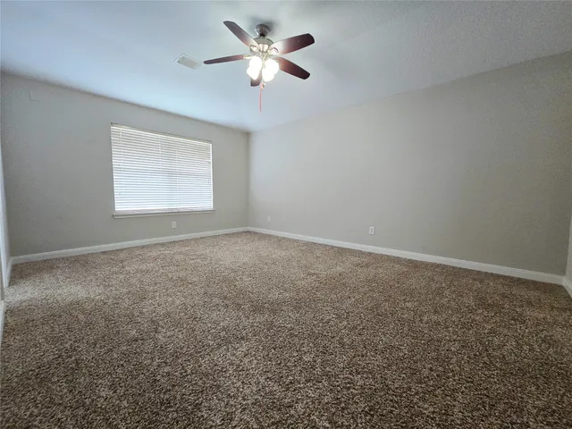 an empty room with a window and a fan