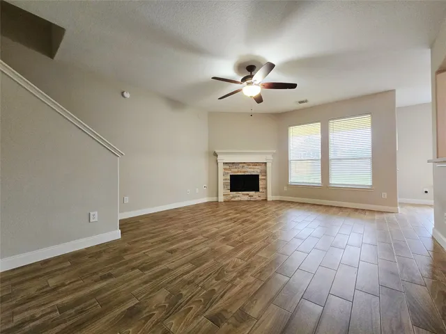 a view of an empty room with a fireplace and a window