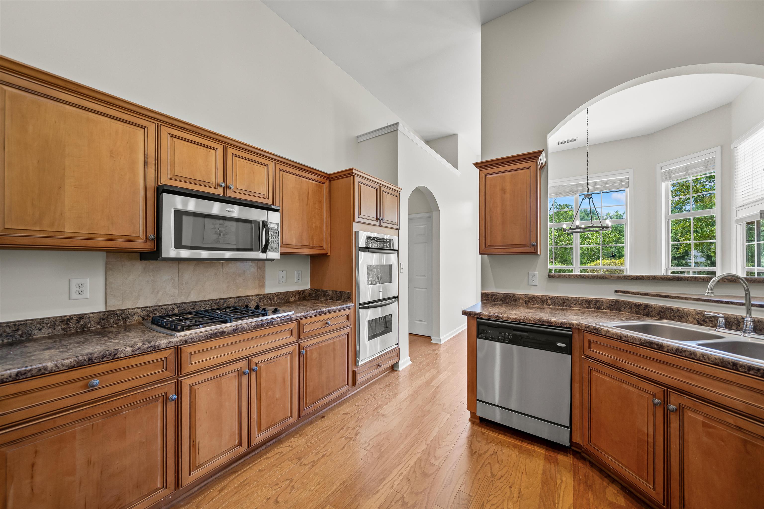 5035 Brian Ridge Road Arlington, TN 38002 - Photo 7 of 40 Kitchen featuring wood-finish cabinetry, stainless steel appliances including a microwave and double ovens, laminate countertops, and wood-finish flooring