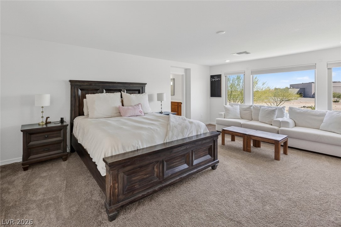 10446 Emerald Rye Street Las Vegas, NV 89183 - Photo 20 of 37 A spacious bedroom retreat offers comfortable living and ample natural light through its large windows.