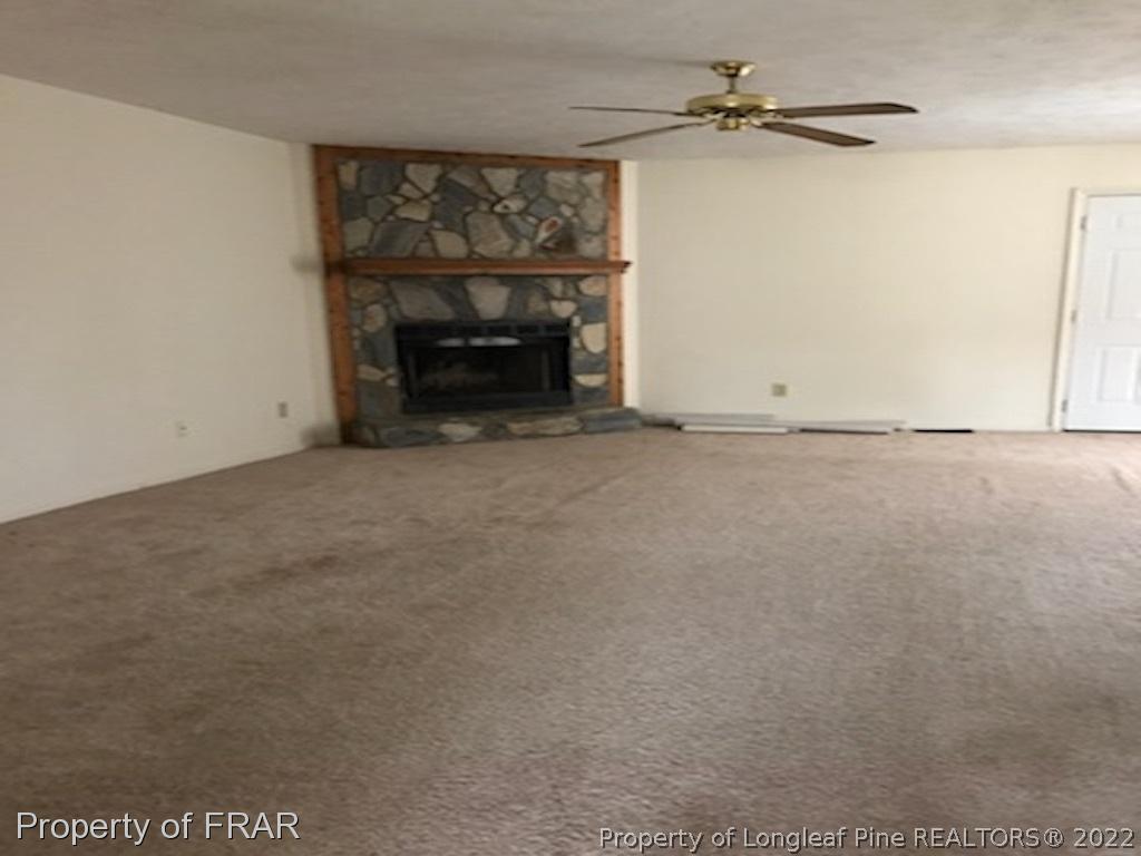 6548 Applewhite Road Fayetteville, NC 28304 - Photo 4 of 10 an empty room with fireplace and windows
