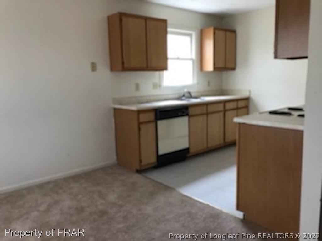 6548 Applewhite Road Fayetteville, NC 28304 - Photo 5 of 10 a kitchen with sink a microwave and cabinets