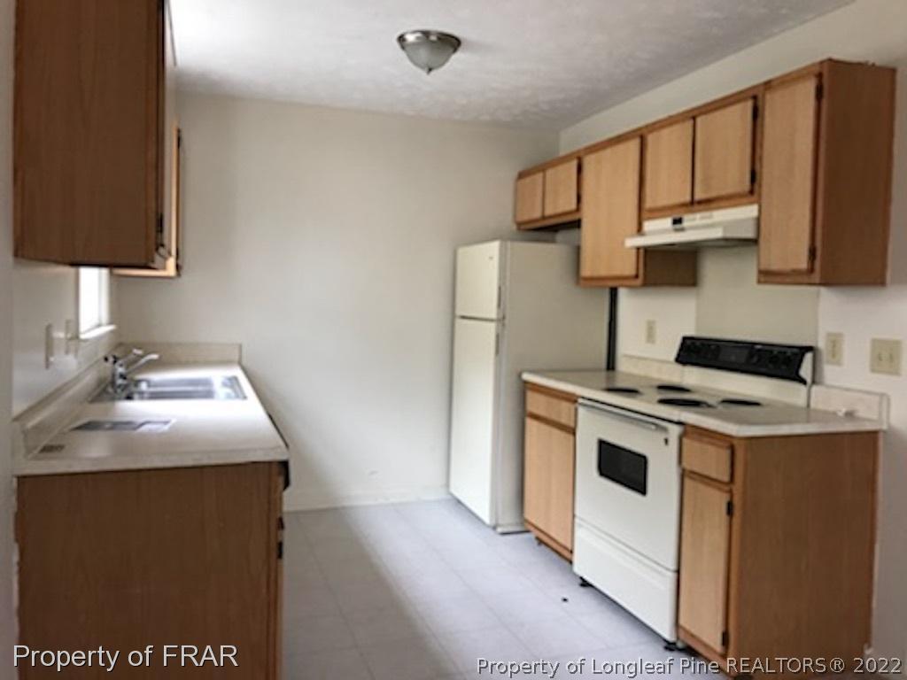 6548 Applewhite Road Fayetteville, NC 28304 - Photo 6 of 10 a kitchen with a sink a stove and a refrigerator