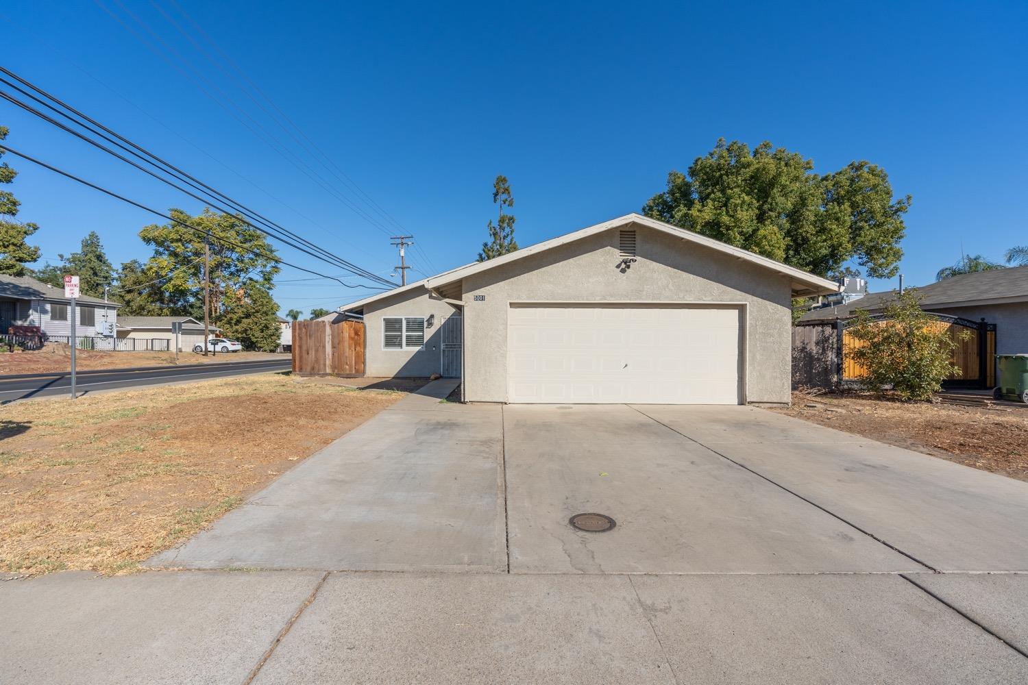 5001 Frona Drive Modesto, CA 95357 - Photo 1 of 1 a front view of a house with a yard and garage