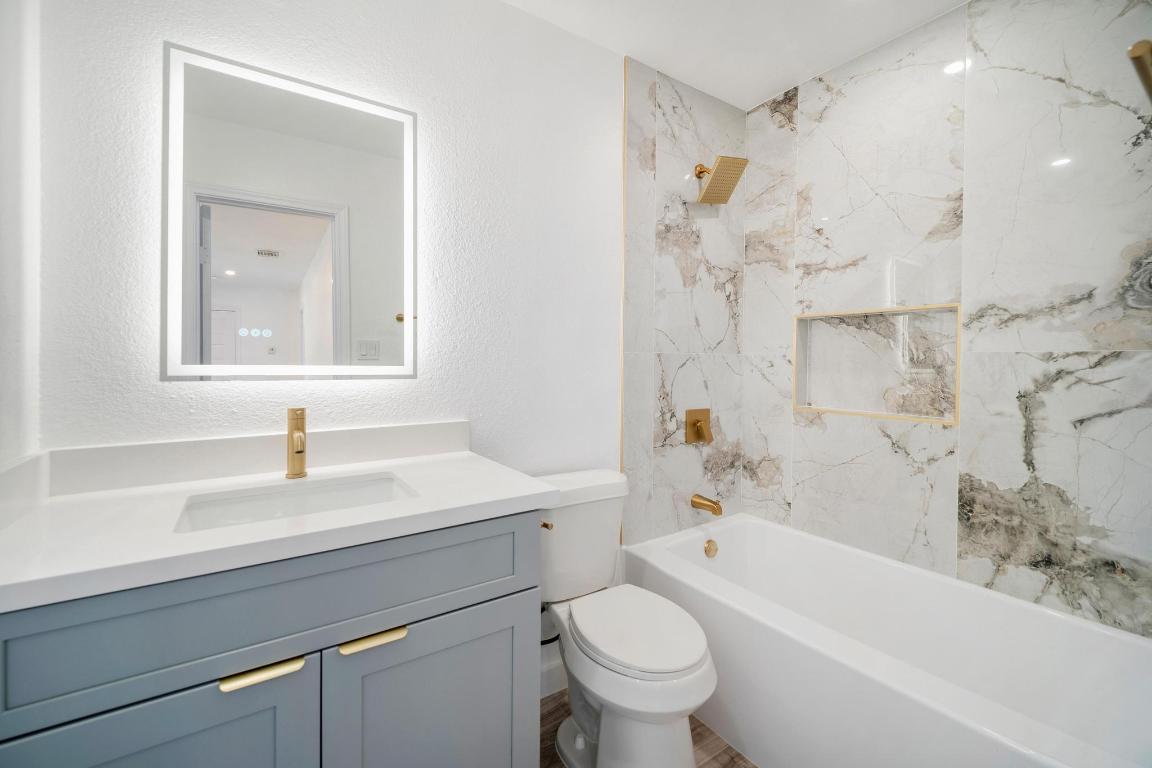 13501 Sierra Wind Lane Elgin, TX 78621 - Photo 24 of 31 Bathroom with a combined bath / shower with marble appearance, vanity, and a textured wall
