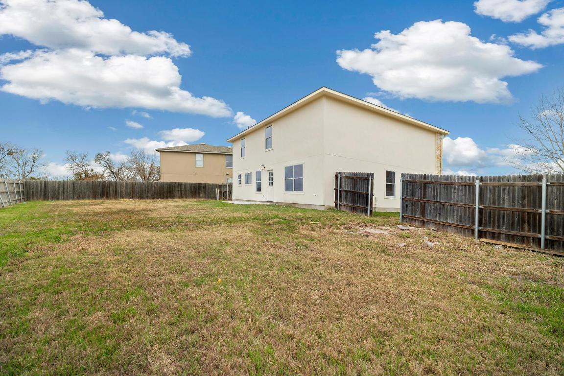 13501 Sierra Wind Lane Elgin, TX 78621 - Photo 28 of 31 Rear view of house featuring a fenced backyard and stucco siding