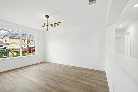 wooden floor in an empty room with a window