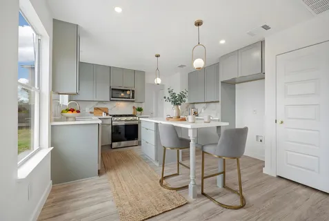 a kitchen with kitchen island granite countertop a sink appliances and cabinets