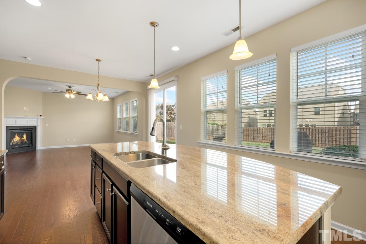 2433 Pilsley Road Apex, NC 27539 - Photo 12 of 28 a kitchen with granite countertop a sink and a wooden floor