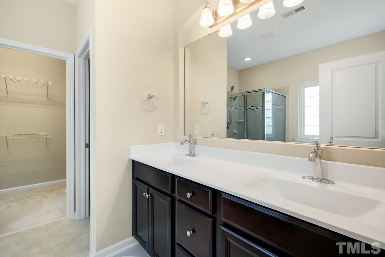 2433 Pilsley Road Apex, NC 27539 - Photo 16 of 28 a bathroom with a double vanity sink a and mirror