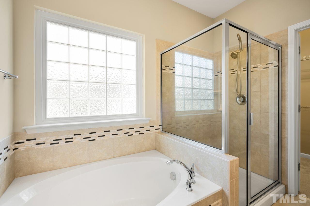2433 Pilsley Road Apex, NC 27539 - Photo 17 of 28 a bathroom with a bathtub and shower