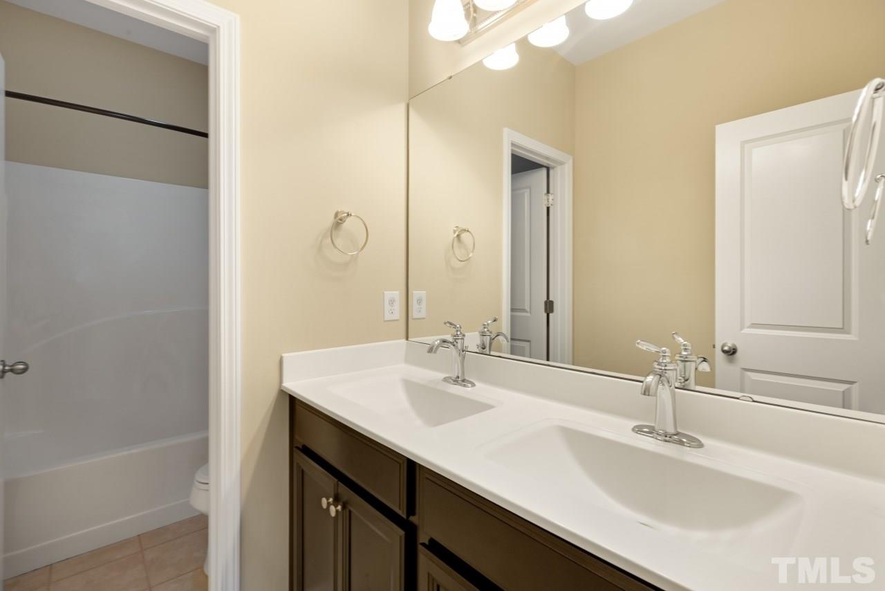 2433 Pilsley Road Apex, NC 27539 - Photo 20 of 28 a bathroom with a sink and a mirror