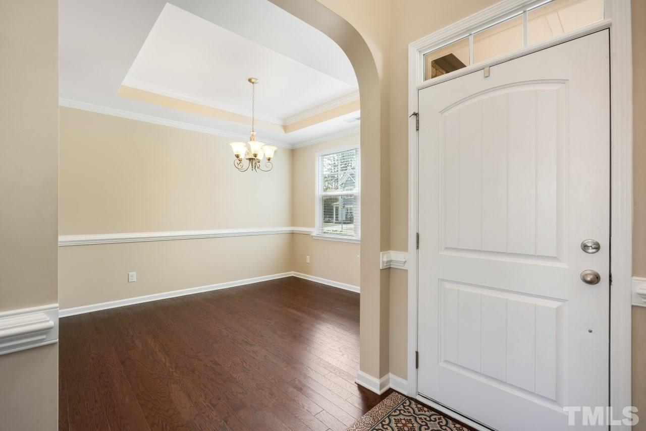 2433 Pilsley Road Apex, NC 27539 - Photo 4 of 28 an empty room with wooden floor cabinet and windows