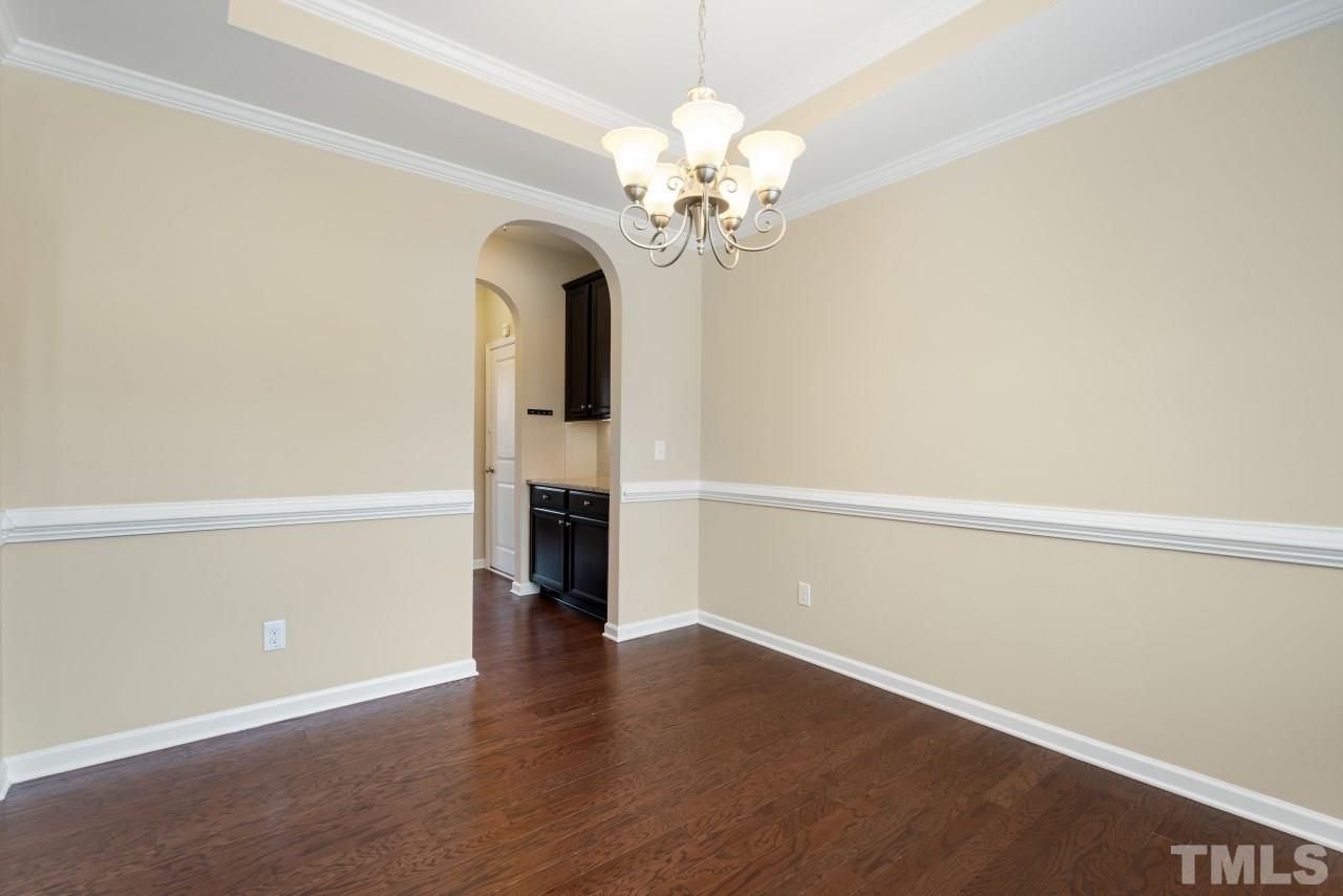 2433 Pilsley Road Apex, NC 27539 - Photo 5 of 28 a view of a room with wooden floor and chandelier